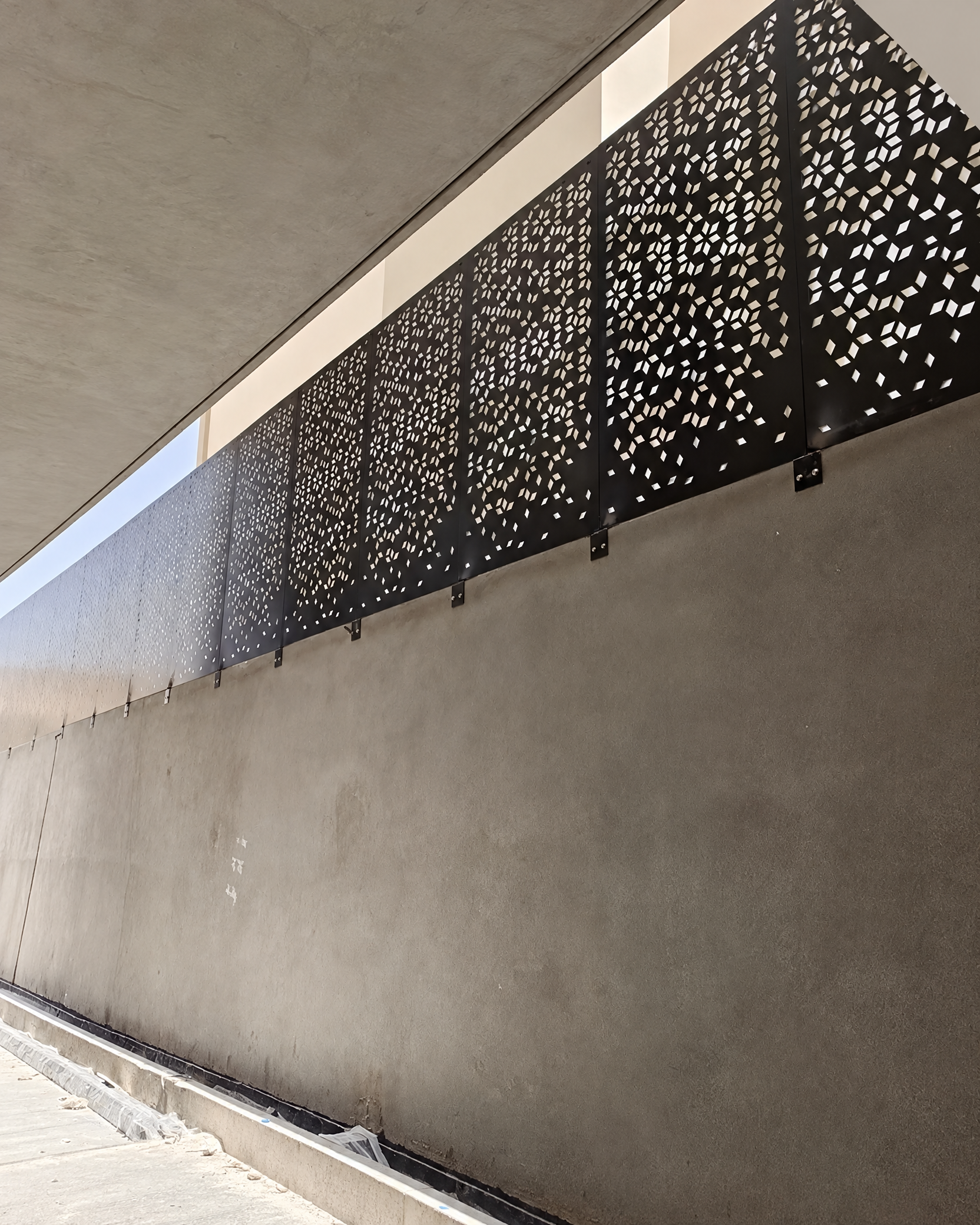 ساتر معدني أسود مثقّب بنقوش هندسية على واجهة خارجية؛ صورة أرسلها المستخدم