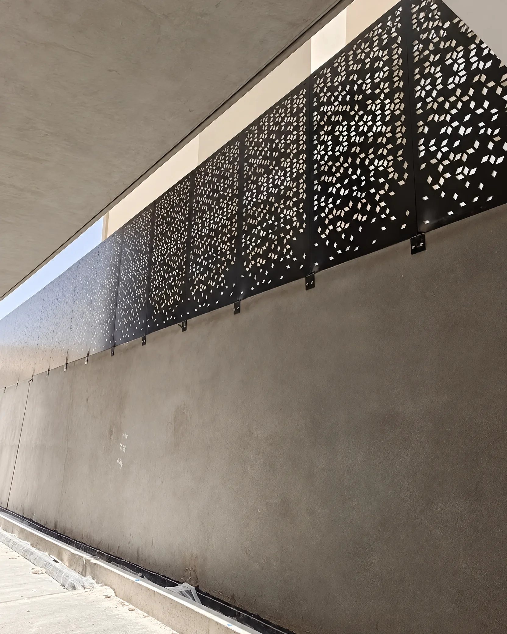 ساتر معدني أسود مثقّب بنقوش هندسية على واجهة خارجية، صورة أرسلها المستخدم